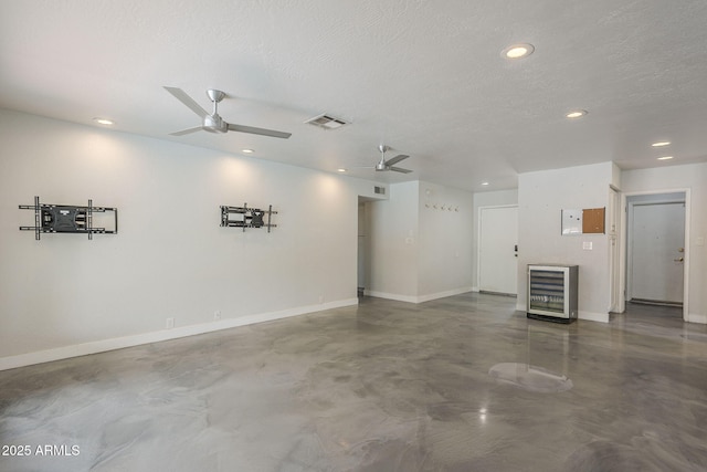 5330 E Tierra Buena Ln, Scottsdale, AZ 85254 - unfurnished living room with concrete flooring, ceiling fan, baseboards, recessed lighting, and beverage cooler