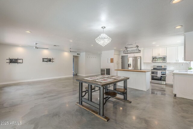 5330 E Tierra Buena Ln, Scottsdale, AZ 85254 - dining space with finished concrete floors, recessed lighting, ceiling fan, a chandelier, and baseboards