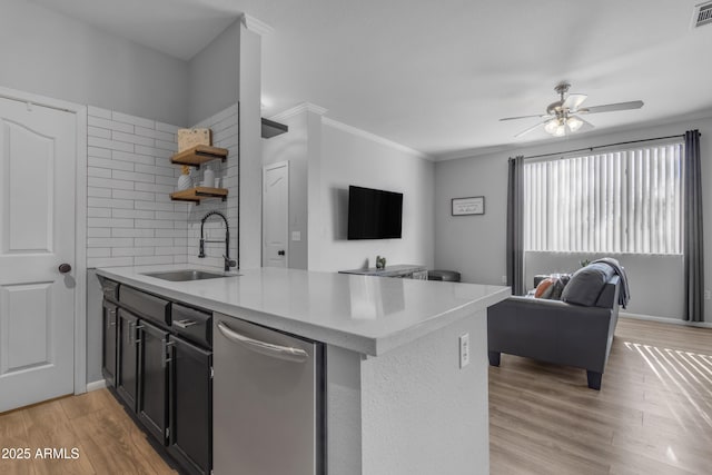 kitchen with ceiling fan, sink, backsplash, kitchen peninsula, and ornamental molding