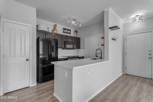 kitchen with kitchen peninsula, light wood-type flooring, sink, and black appliances