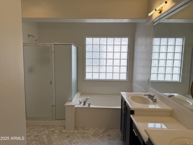 full bathroom with a bath, a shower stall, two vanities, and a sink