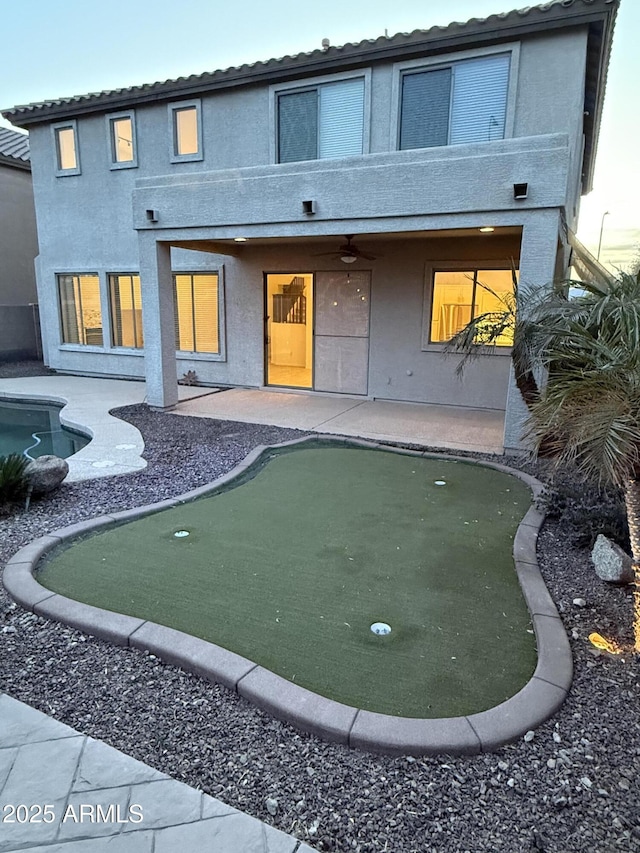 back of house featuring a patio, a balcony, a ceiling fan, and stucco siding