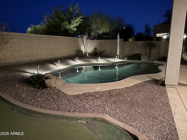 pool at twilight featuring a fenced in pool and a fenced backyard