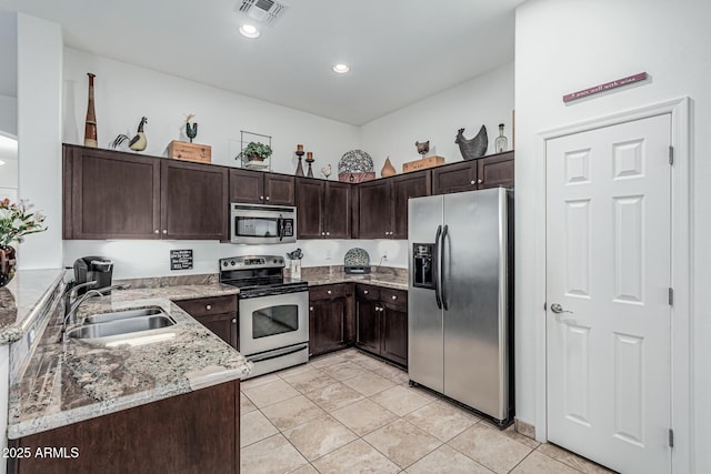 582 W Stirrup Ln, San Tan Valley, AZ 85143 - kitchen with a sink, visible vents, dark brown cabinetry, light stone countertops, and appliances with stainless steel finishes