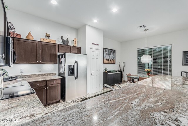 582 W Stirrup Ln, San Tan Valley, AZ 85143 - kitchen featuring dark brown cabinets, light stone countertops, visible vents, and stainless steel appliances