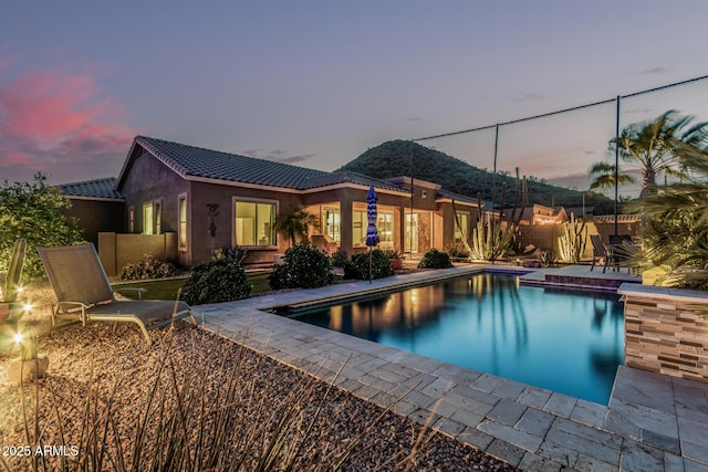 582 W Stirrup Ln, San Tan Valley, AZ 85143 - pool at dusk with fence, an outdoor pool, and a patio