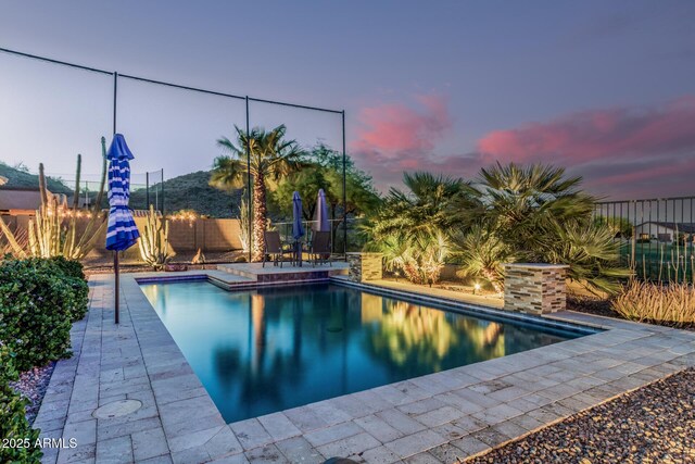 582 W Stirrup Ln, San Tan Valley, AZ 85143 - pool at dusk with a fenced backyard, a fenced in pool, and a patio
