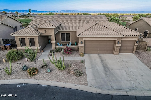 582 W Stirrup Ln, San Tan Valley, AZ 85143 - view of front of home featuring concrete driveway, a tiled roof, an attached garage, a mountain view, and stucco siding