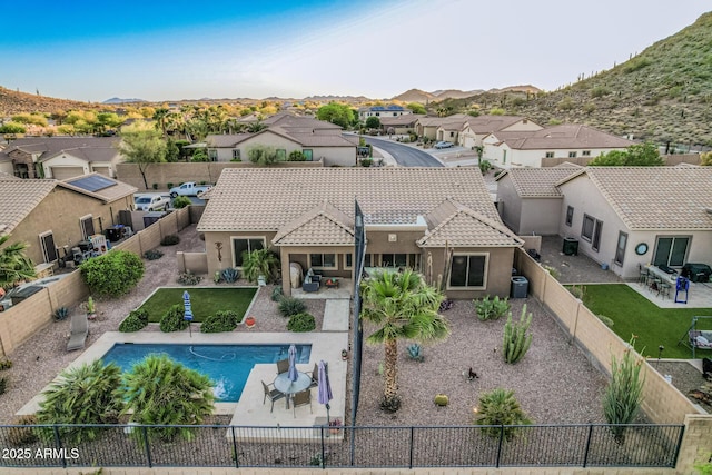 582 W Stirrup Ln, San Tan Valley, AZ 85143 - back of house with a tile roof, a patio area, a fenced backyard, stucco siding, and a residential view