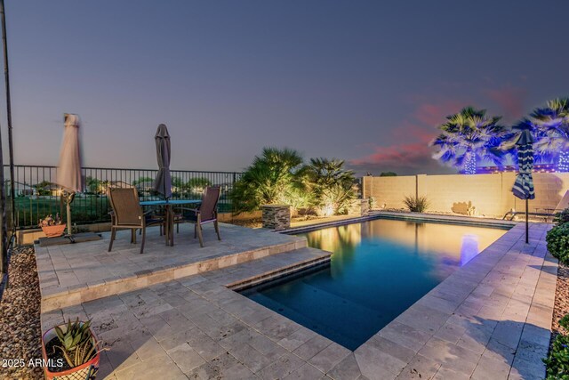 582 W Stirrup Ln, San Tan Valley, AZ 85143 - pool at dusk with a patio area, a fenced in pool, outdoor dining area, and a fenced backyard