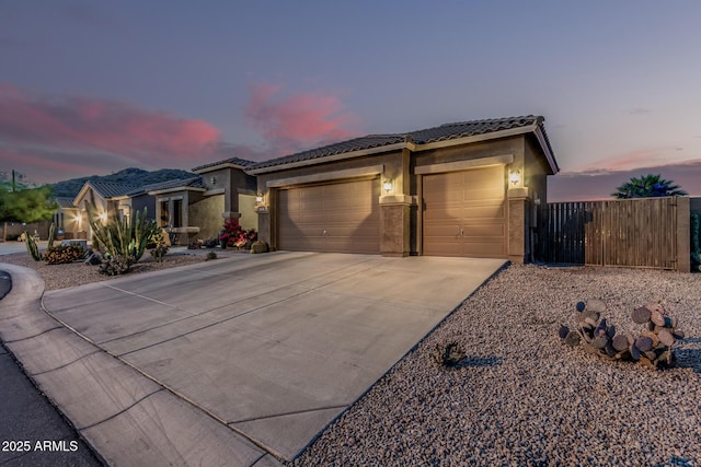 582 W Stirrup Ln, San Tan Valley, AZ 85143 - view of front of home featuring a tile roof, concrete driveway, fence, a garage, and stucco siding
