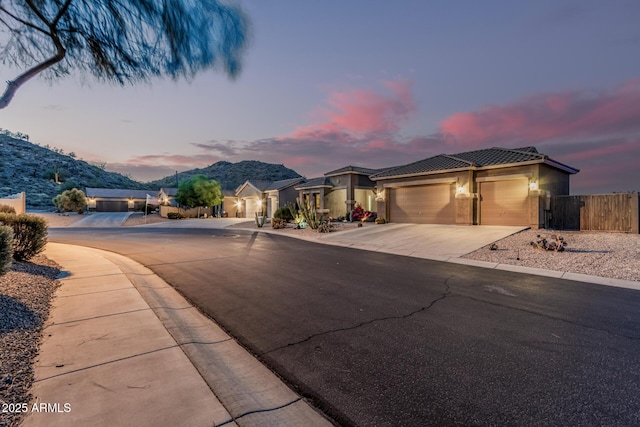 582 W Stirrup Ln, San Tan Valley, AZ 85143 - view of front of house featuring a tile roof, driveway, an attached garage, fence, and stucco siding