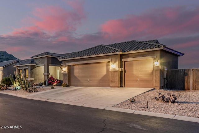 582 W Stirrup Ln, San Tan Valley, AZ 85143 - view of front of property featuring driveway, a tiled roof, an attached garage, fence, and stucco siding