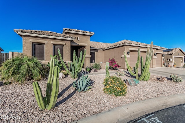 582 W Stirrup Ln, San Tan Valley, AZ 85143 - view of front facade featuring a garage, concrete driveway, a tiled roof, and stucco siding