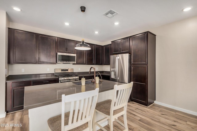 1153 W Diamondback Dr, Chandler, AZ 85286 - kitchen featuring stainless steel appliances, a sink, baseboards, dark brown cabinetry, and light wood-style flooring