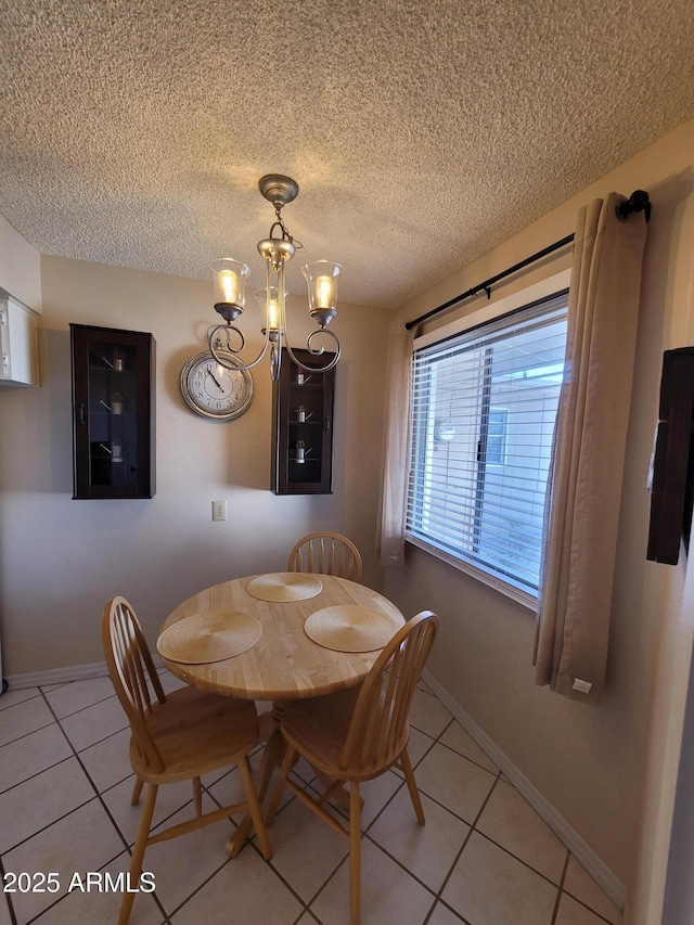 tiled dining area featuring a textured ceiling and an inviting chandelier