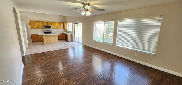 kitchen featuring light hardwood / wood-style floors, appliances with stainless steel finishes, ceiling fan, and a kitchen island