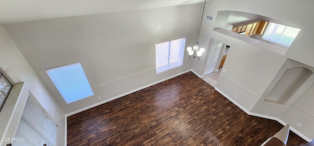 entryway featuring hardwood / wood-style flooring, a notable chandelier, and a towering ceiling