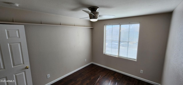 spare room with ceiling fan and dark hardwood / wood-style flooring