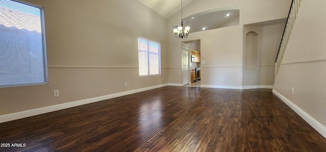 unfurnished room with high vaulted ceiling, dark hardwood / wood-style floors, and a notable chandelier