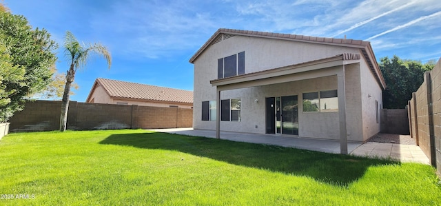 back of property with a yard and a patio