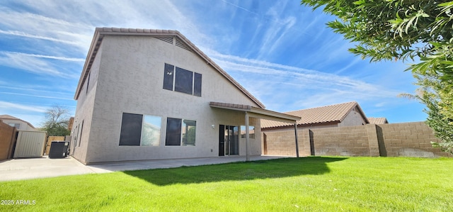 rear view of house featuring a patio, cooling unit, and a lawn