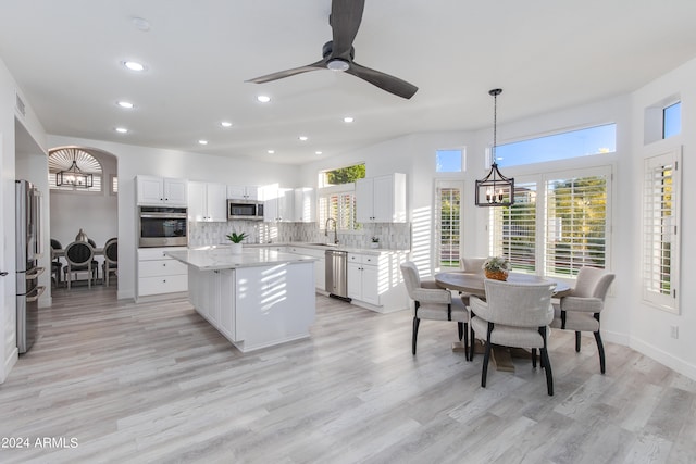 kitchen featuring a healthy amount of sunlight, white cabinets, light hardwood / wood-style floors, and stainless steel appliances