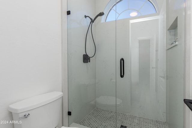 bathroom with a shower with door and toilet