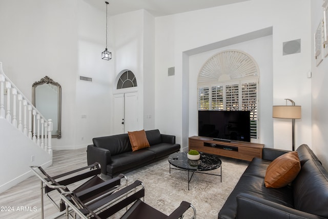 living room with high vaulted ceiling and hardwood / wood-style floors