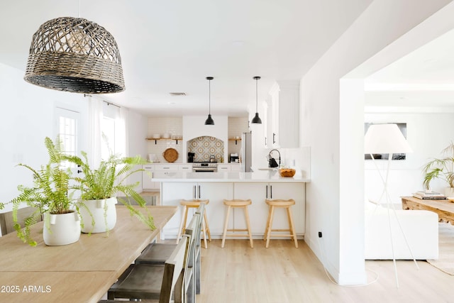 dining room featuring sink and light hardwood / wood-style floors