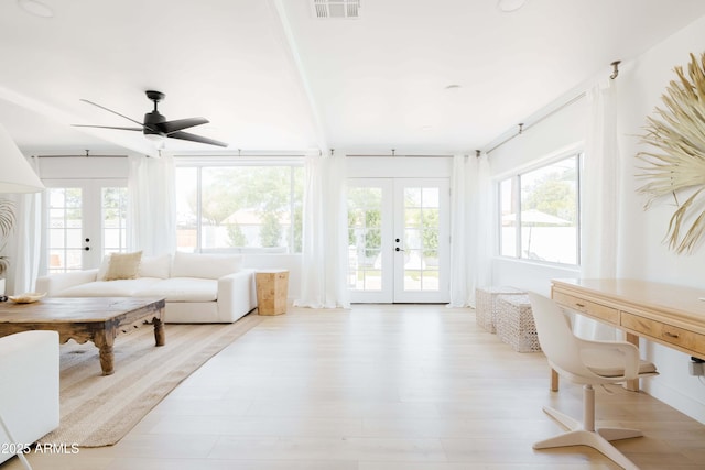 sunroom / solarium featuring french doors, ceiling fan, and a wealth of natural light