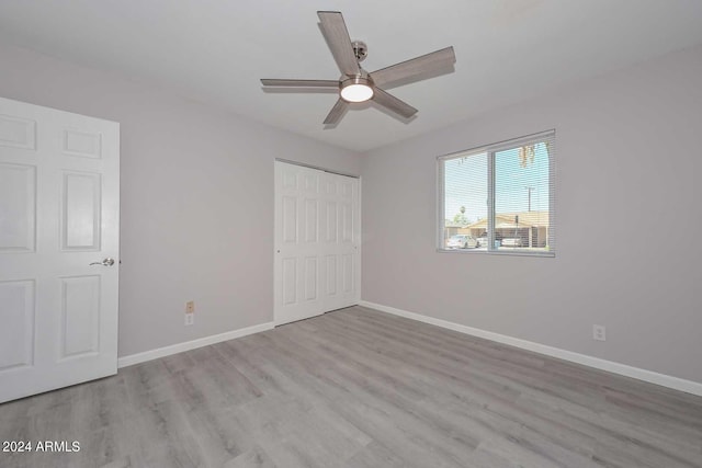 unfurnished bedroom with a closet, light hardwood / wood-style flooring, and ceiling fan