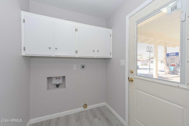 laundry room with hookup for an electric dryer, hookup for a washing machine, light hardwood / wood-style floors, and cabinets