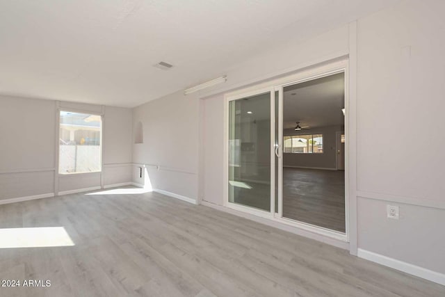 spare room featuring ceiling fan, plenty of natural light, and light hardwood / wood-style flooring