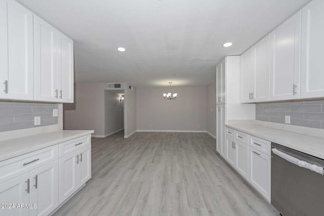 kitchen featuring white cabinetry, tasteful backsplash, stainless steel dishwasher, a notable chandelier, and light wood-type flooring