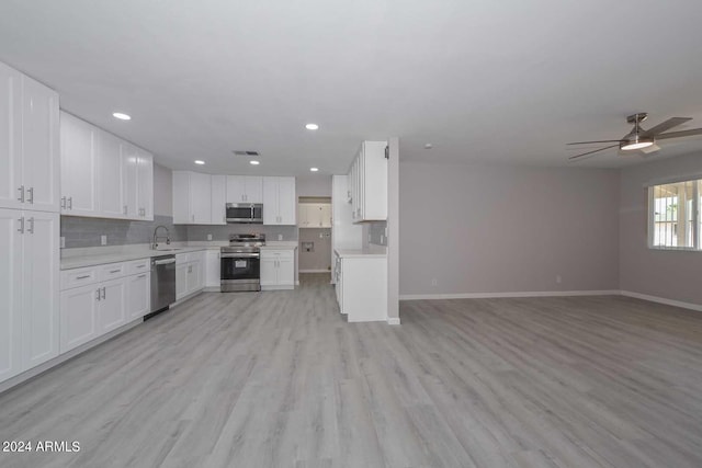 kitchen with decorative backsplash, appliances with stainless steel finishes, ceiling fan, light hardwood / wood-style flooring, and white cabinetry