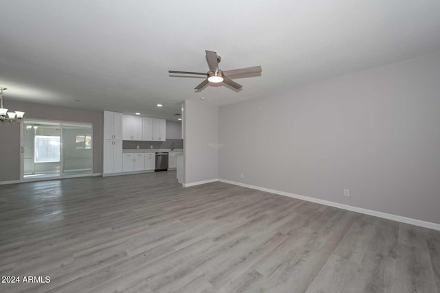 unfurnished living room with ceiling fan with notable chandelier and light wood-type flooring