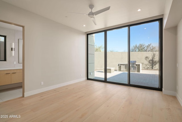 unfurnished room with floor to ceiling windows, ceiling fan, and light hardwood / wood-style floors