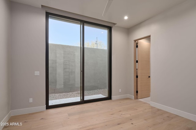 spare room with light hardwood / wood-style flooring and expansive windows