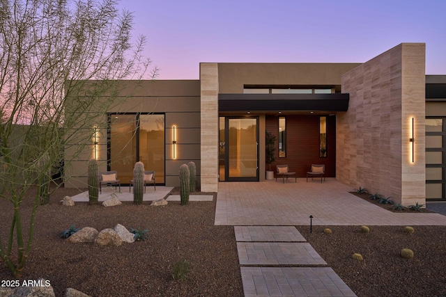 back house at dusk with a patio area