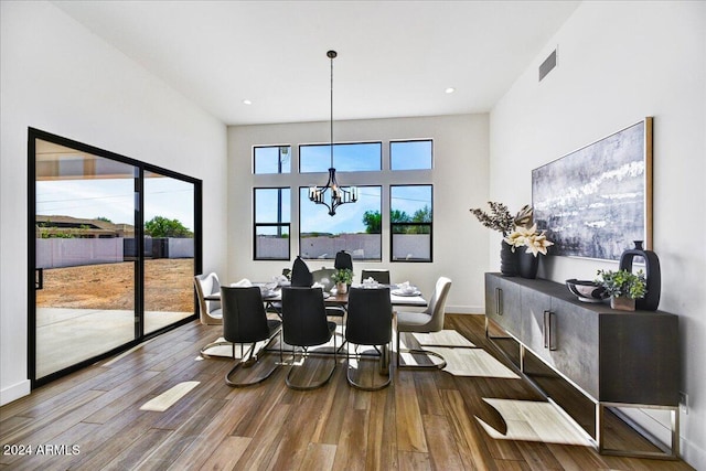 dining room with hardwood / wood-style floors and a chandelier