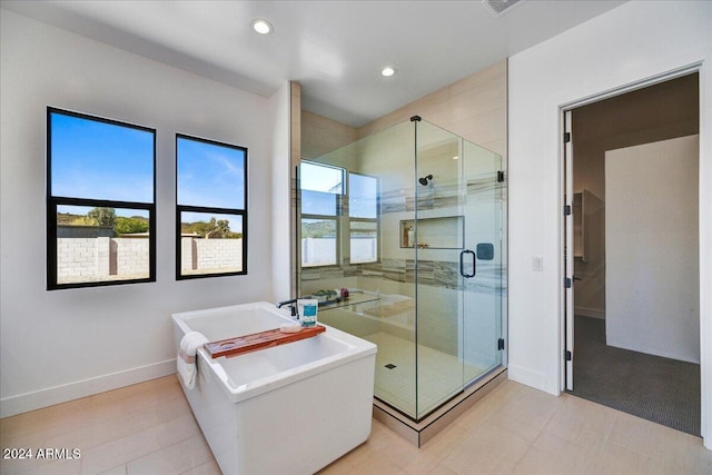 bathroom featuring independent shower and bath and a healthy amount of sunlight