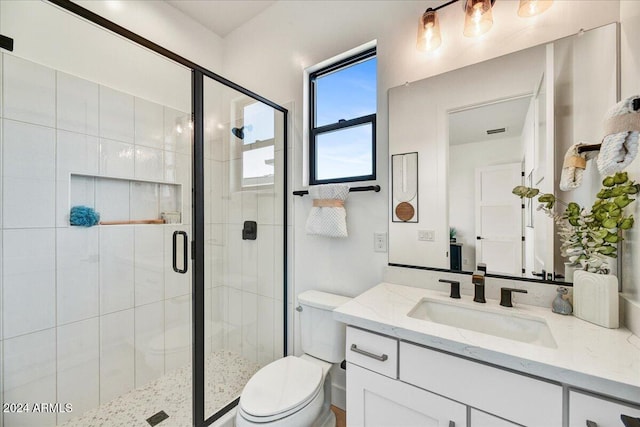 bathroom featuring vanity, an enclosed shower, and toilet