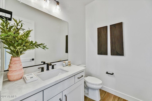 bathroom featuring vanity, hardwood / wood-style flooring, and toilet