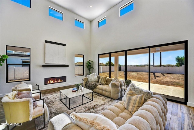 living room featuring a towering ceiling and hardwood / wood-style floors