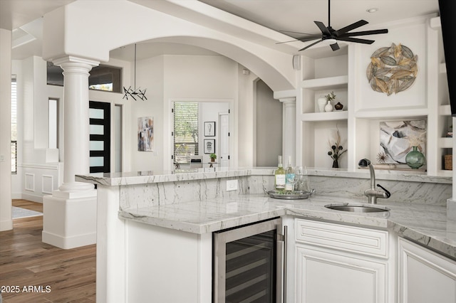 3946 N Pinnacle Hills Cir, Mesa, AZ 85207 - kitchen with beverage cooler, ceiling fan, built in shelves, light wood-style floors, and white cabinetry