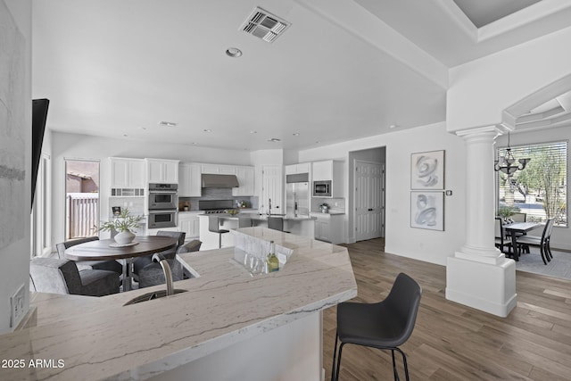 3946 N Pinnacle Hills Cir, Mesa, AZ 85207 - kitchen featuring built in appliances, ornate columns, white cabinets, and recessed lighting