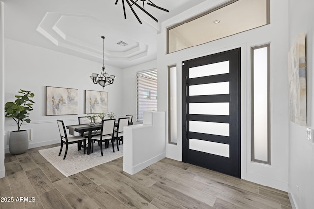 3946 N Pinnacle Hills Cir, Mesa, AZ 85207 - entryway featuring a chandelier, light wood-style floors, and a tray ceiling