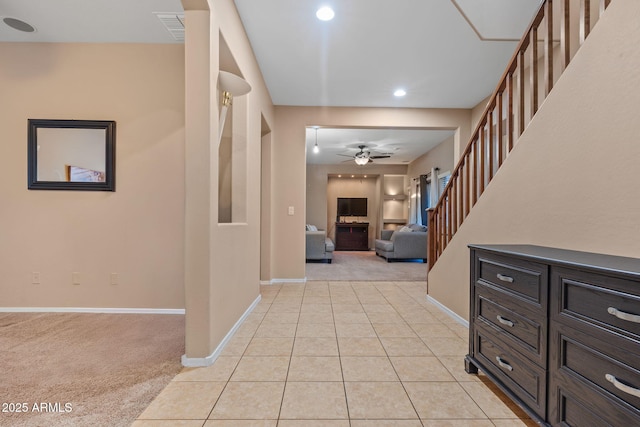 foyer entrance featuring light tile patterned floors, visible vents, light carpet, baseboards, and stairs