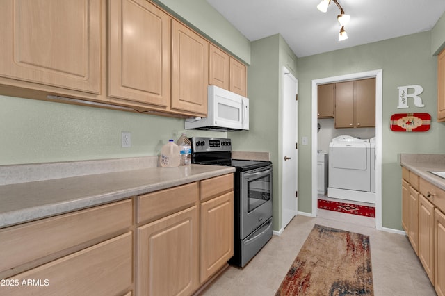 kitchen with rail lighting, light brown cabinets, independent washer and dryer, and stainless steel range with electric cooktop